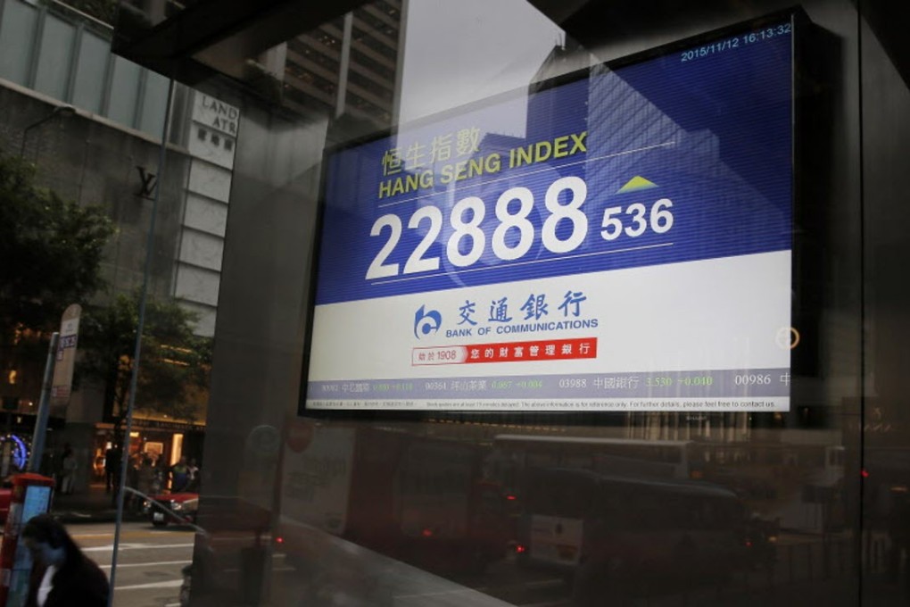 A man walks past an electronic board showing the Hong Kong Stock Exchange in the city’s financial district. Photo: AP