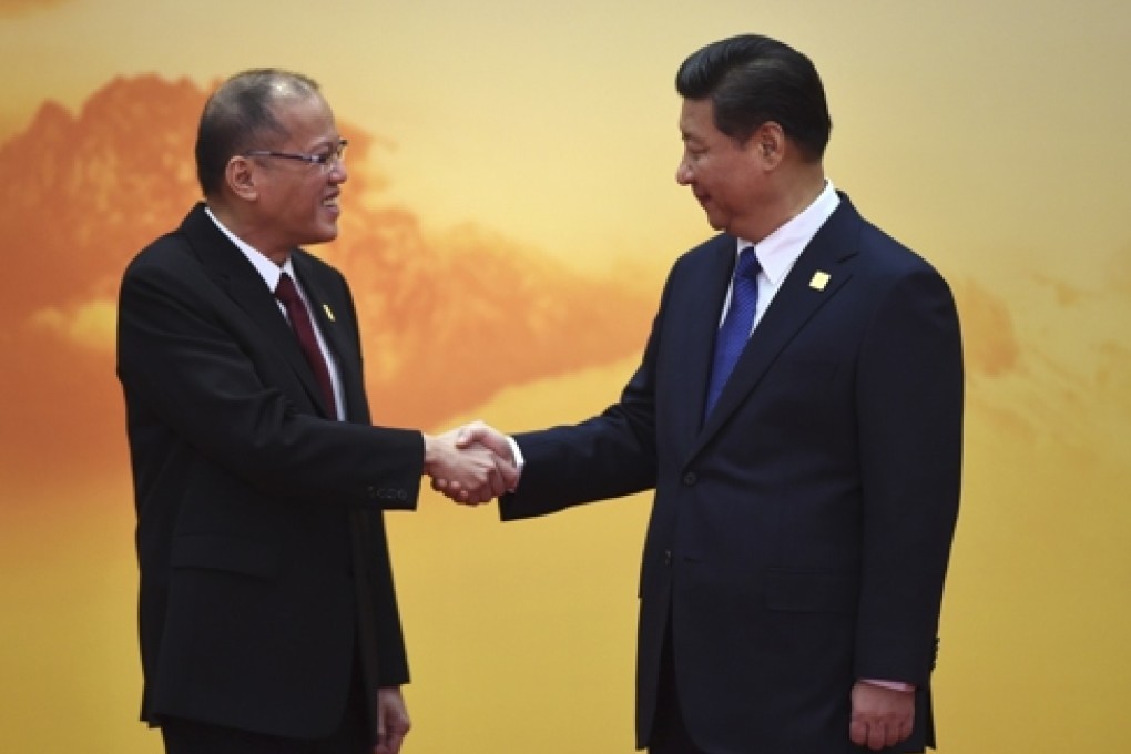 Philippine President Benigno Aquino (L) shakes hands with China's President Xi Jinping as he arrives for the Asia-Pacific Economic Cooperation (APEC) leaders meeting at Yanqi Lake, north of Beijing on November 11, 2014. Top leaders and ministers of the 21-member APEC grouping are meeting in Beijing from November 7 to 11. AFP PHOTO / Greg BAKER