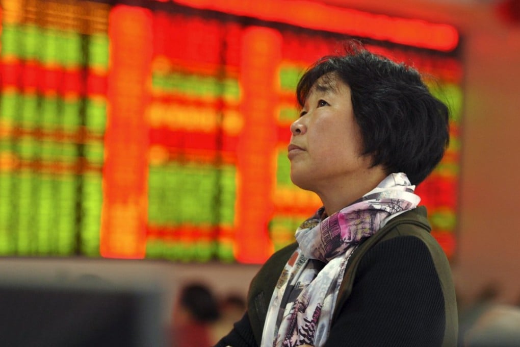 An investor stands in front of an electronic board showing stock information at a brokerage house in Fuyang, Anhui province, on October 26. Photo: Reuters