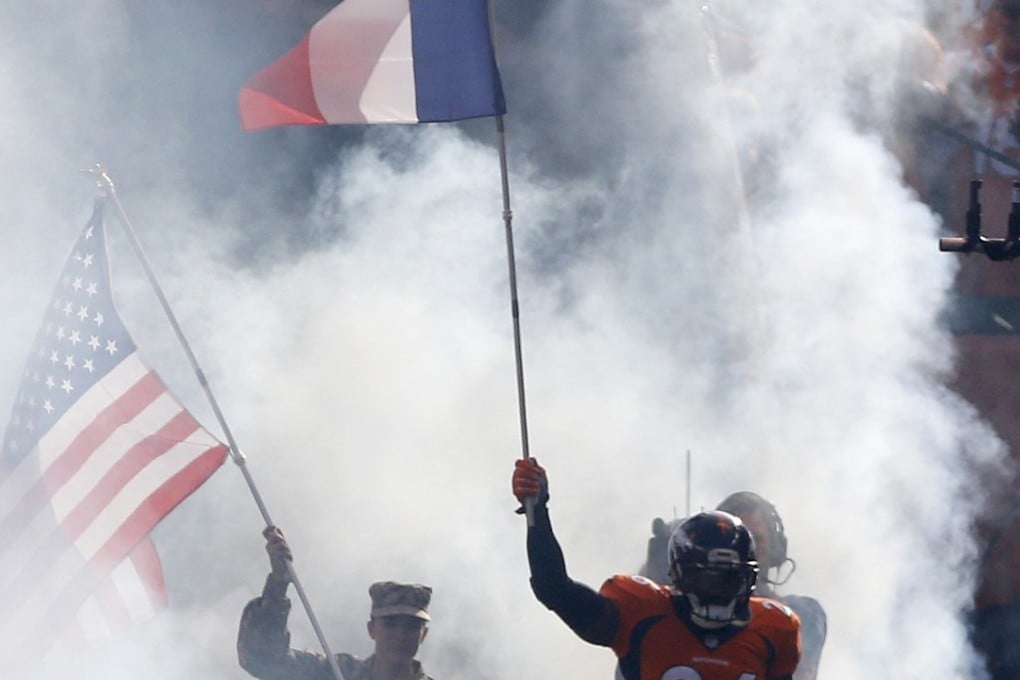 Denver Broncos free safety Darian Stewart carries the French flag as he takes to the field for an NFL game against the Kansas City Chiefs in Denver. Photo: AP
