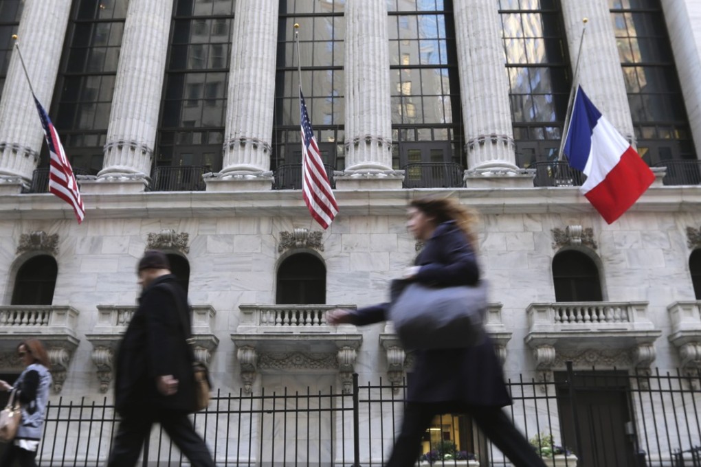 A French flag flies at half staff in front of the New York Stock Exchange on Monday in the wake of the terrorist attacks in Paris last Friday. Photo: AP