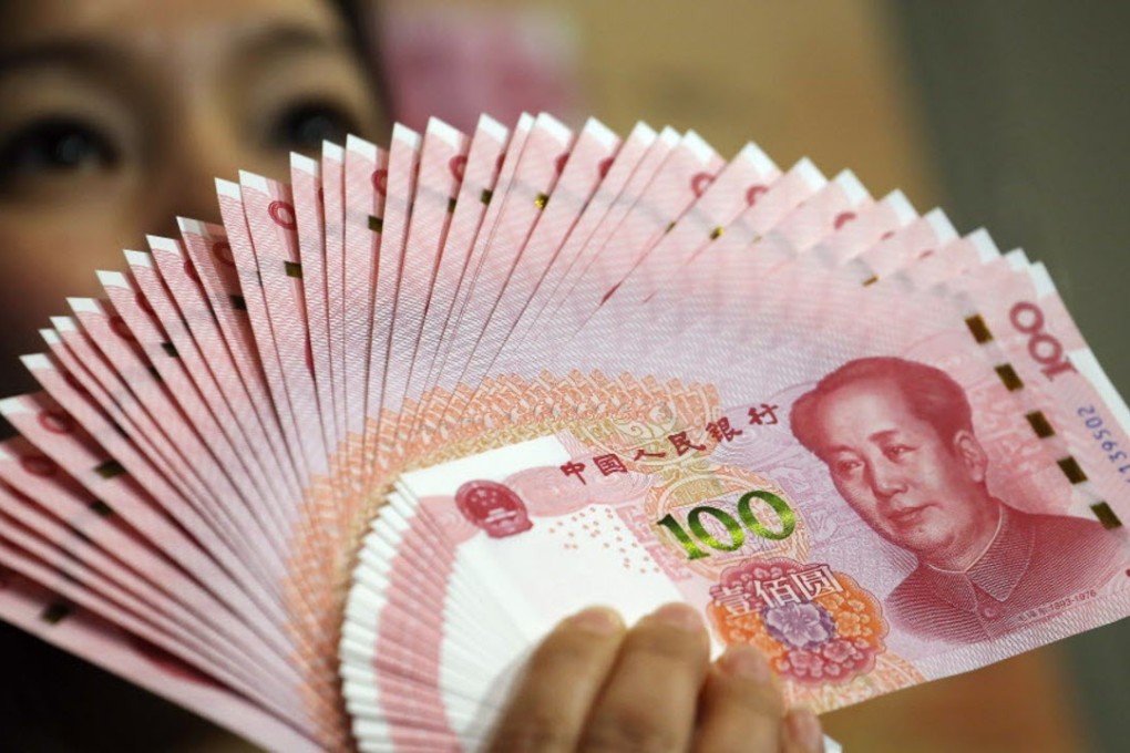 A customer holds 100 yuan notes at a market in Beijing as tit-for-tat currency depreciations with rival Japan seems to have slowed down for now. Photo: Reuters