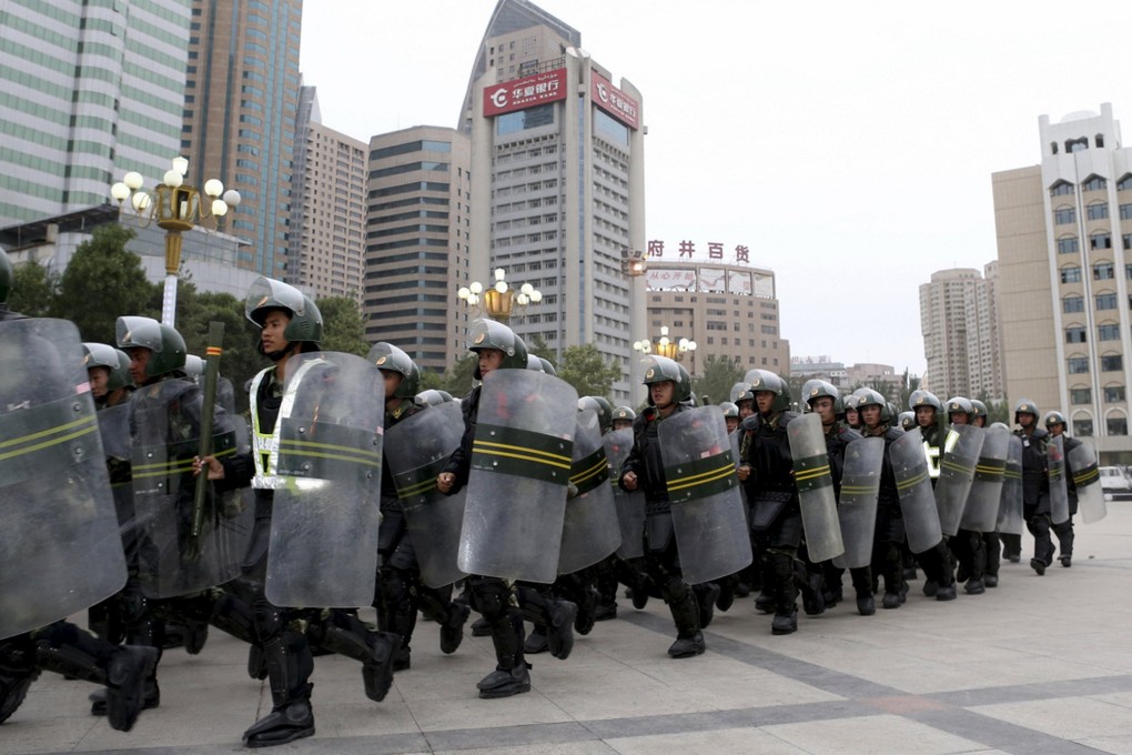 Armed paramilitary policemen run in formation during a gathering to mobilize security operations in Urumqi, Xinjiang, in June, 2013. Photo: Reuters