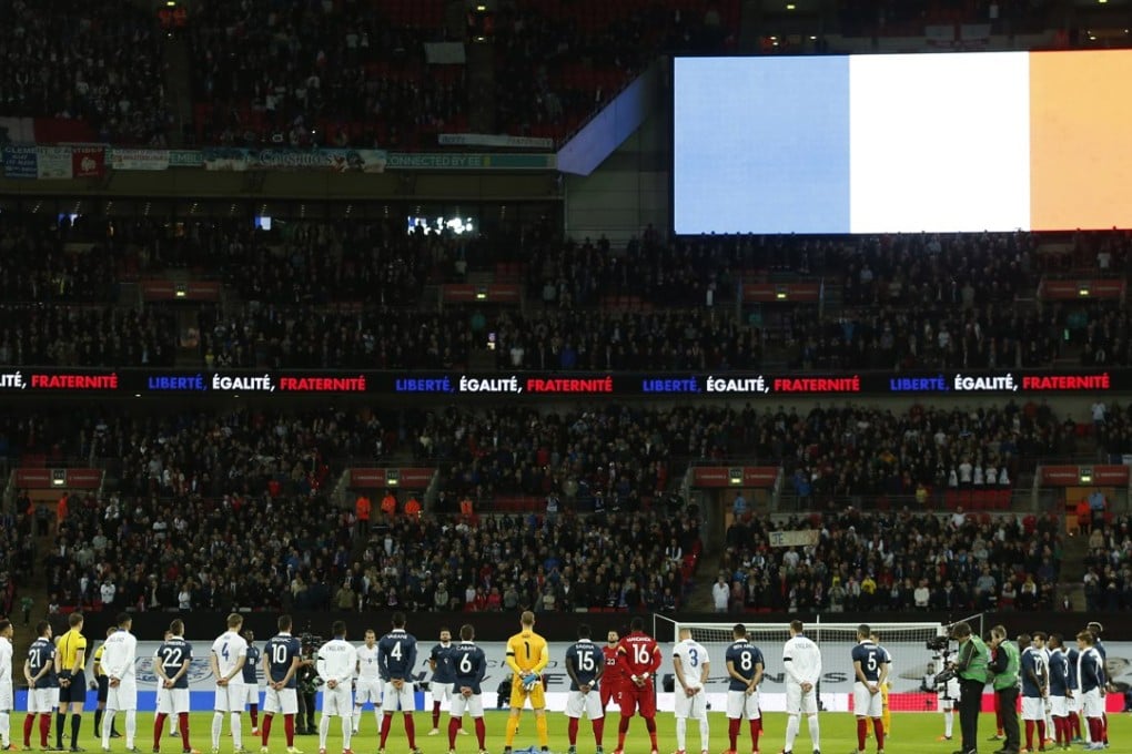 England and France players stand should to shoulder during a minute’s silence in memory of the Paris attacks before the match at Wembley. Photo: Reuters