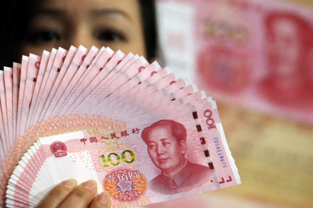 New 100 renmimbi notes are held up at a bank in the central business district of Hong Kong. Photo: Reuters