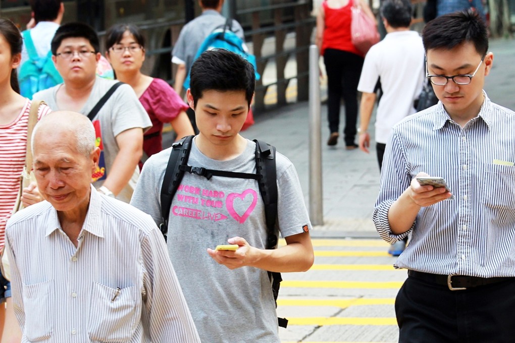 People using mobile devices on a street in Hong Kong. Picture: May Tse