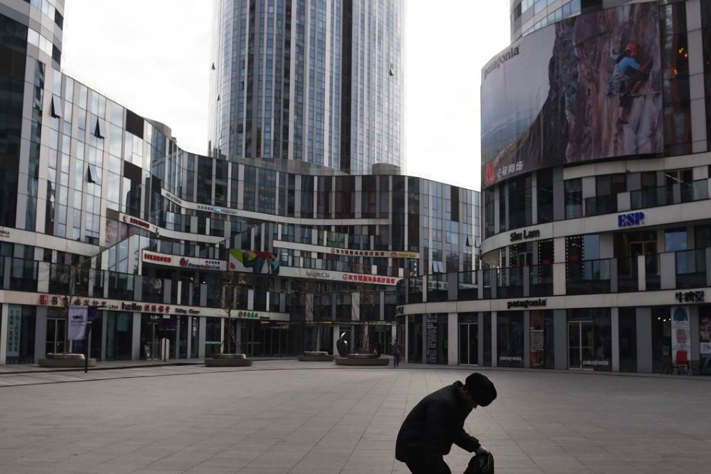 A worker picks up trash in a shopping complex in Beijing as the economic slowdown in China takes its toll on the economy. Photo: AFP