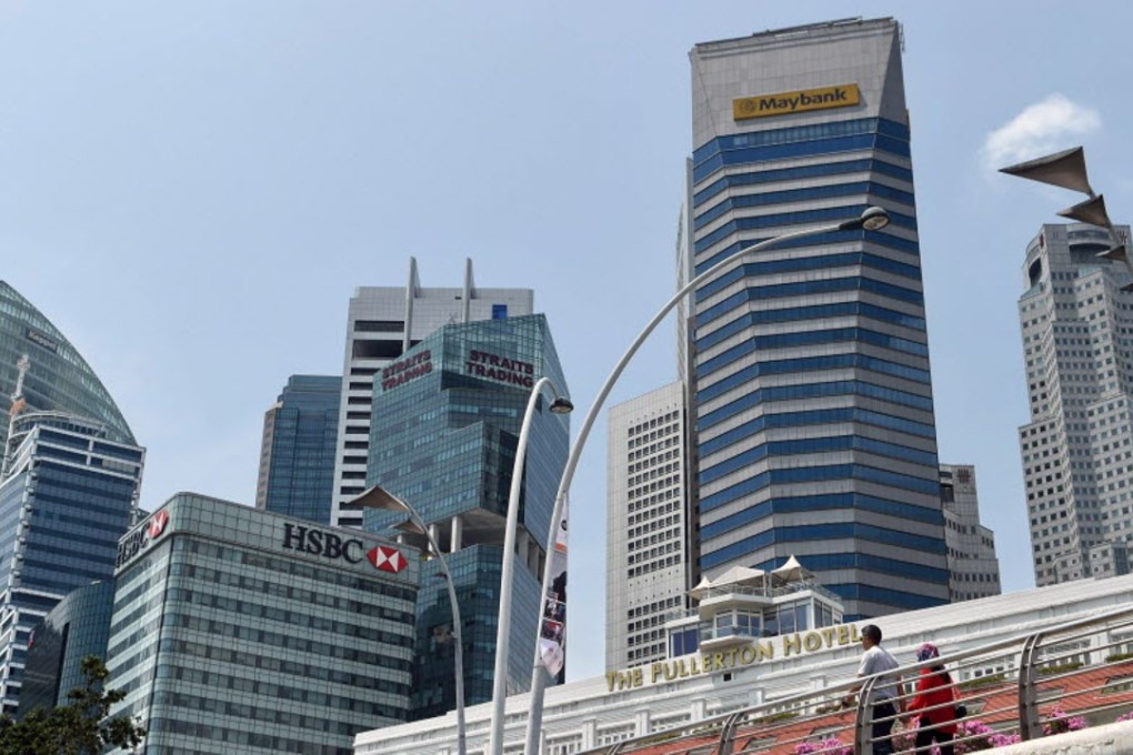 A couple walks across the bridge next to the financial business district in Singapore. Photo: AFP