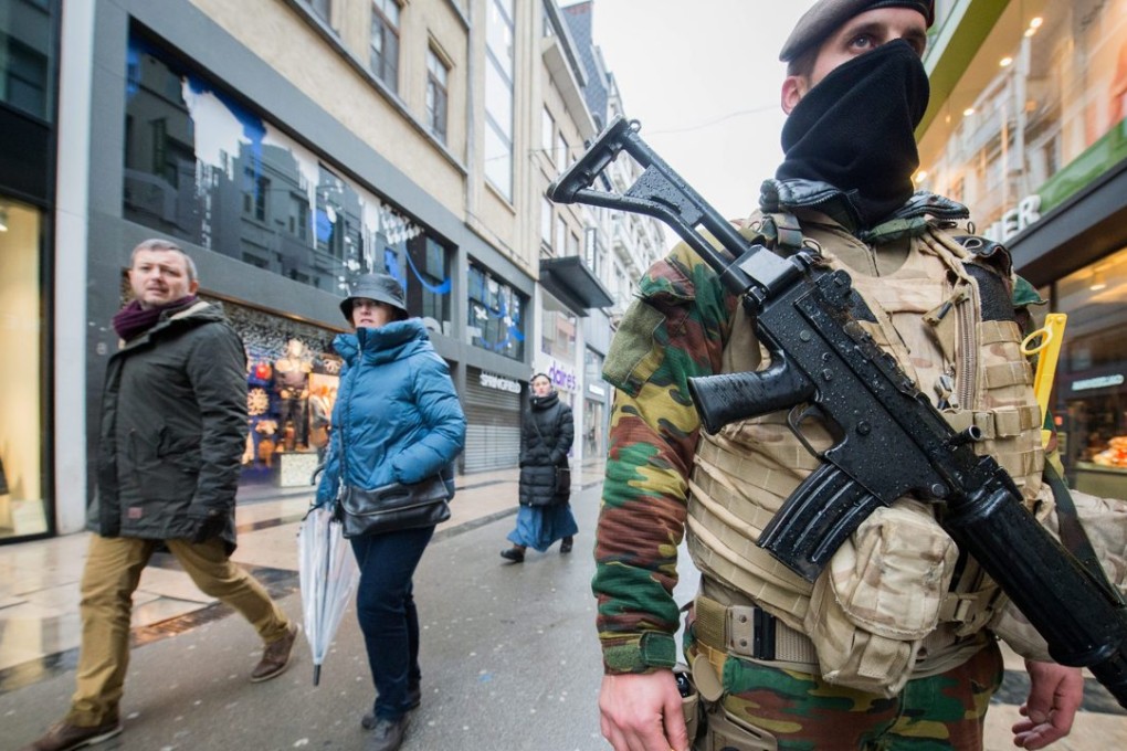 Soldiers and police patrol in Rue Neuve, the biggest shopping street in Brussels where all stores had to close following the terror alert level being elevated. Photo: EPA