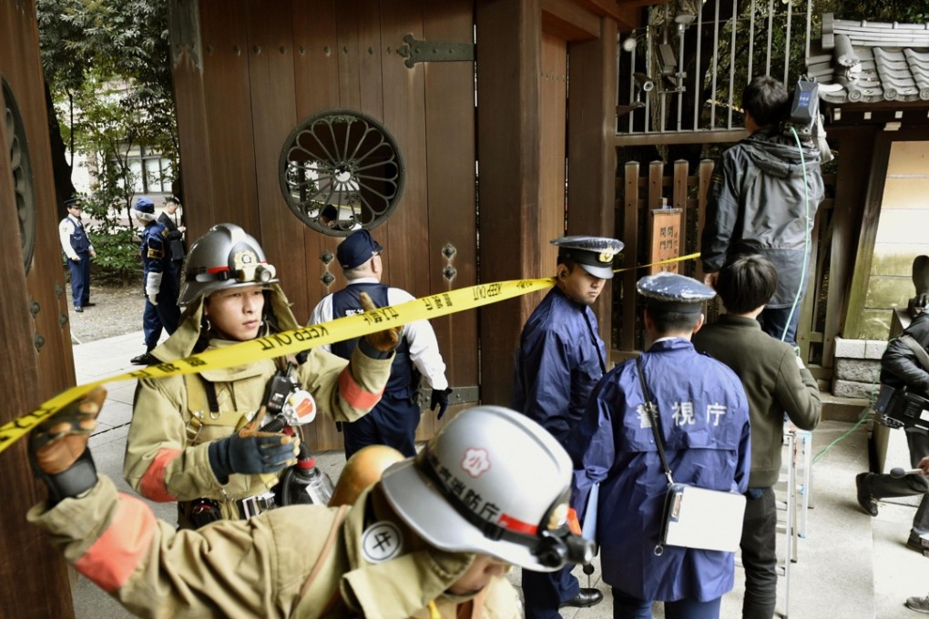 Firefighters and police officers inspect the area near the south gate of Yasukuni Shrine in Tokyo after an explosion was reported in a public restroom. Photo: Kyodo