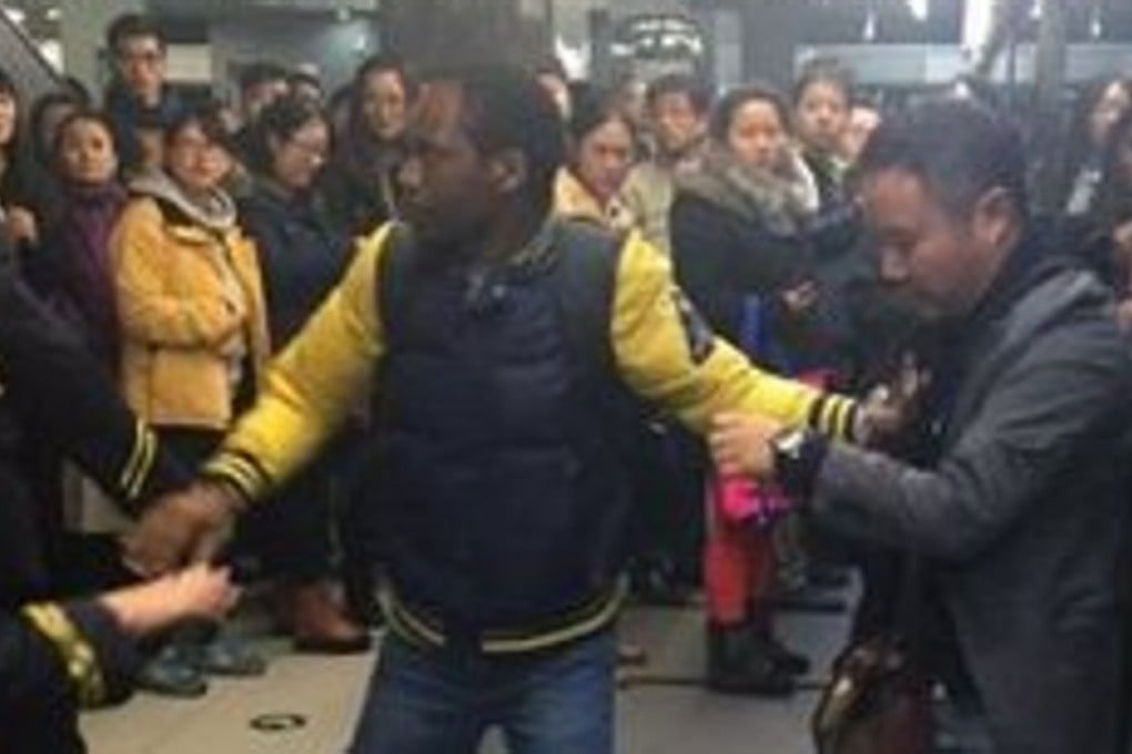 The Beijing subway fight between two mainland commuters, which saw a foreigner (centre) intervene, was captured on CCTV cameras and posted online. Photo: Weibo