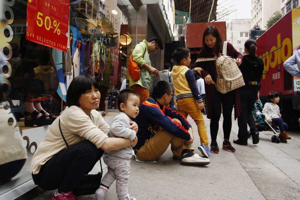 Mainland Chinese visitors rest outside a shop in Hong Kong. Photo: Reuters