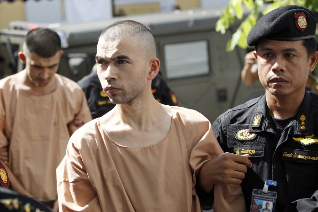 Police officers escort suspects Bilal Mohammad, front, and Mieraili Yusufu, rear, as they arrive at a military court in Bangkok. Photo: AP