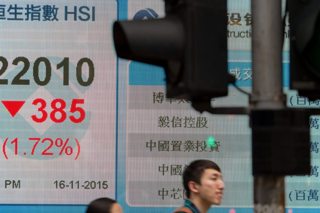 Pedestrians stroll by an electronic board showing the Hang Seng Index in Hong Kong. Photo: EPA