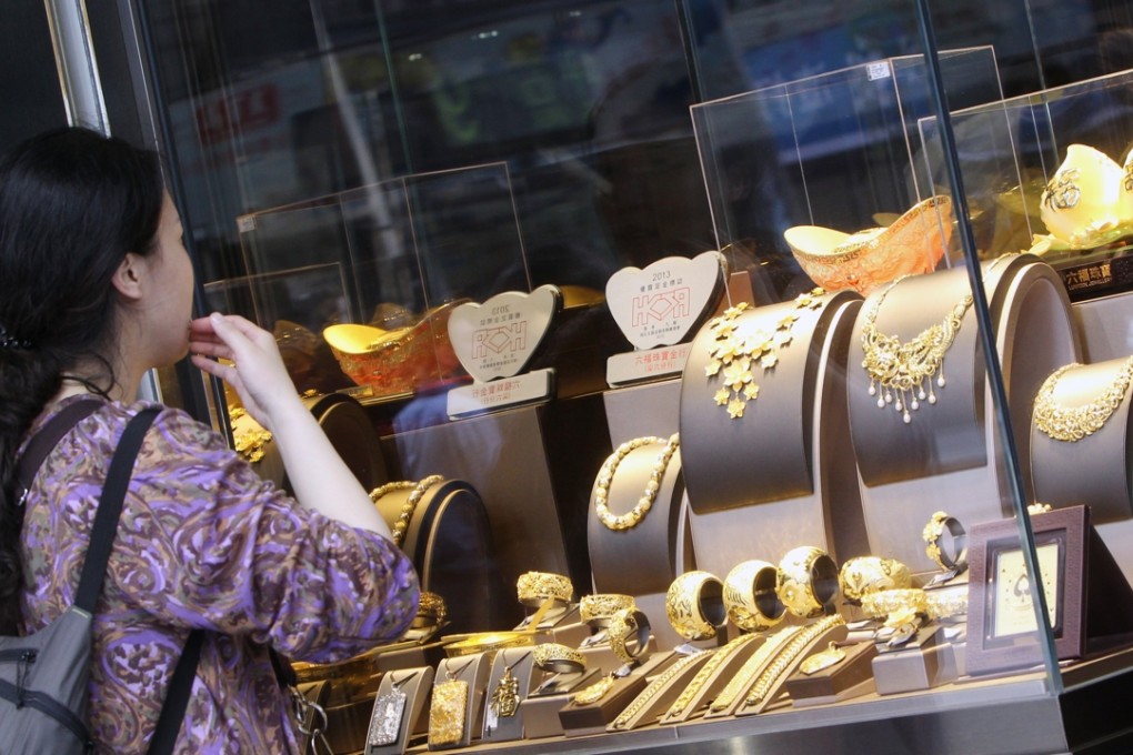 A woman looks at gold products in a jewellery shop in Tsim Sha Tsui. Photo: David Wong