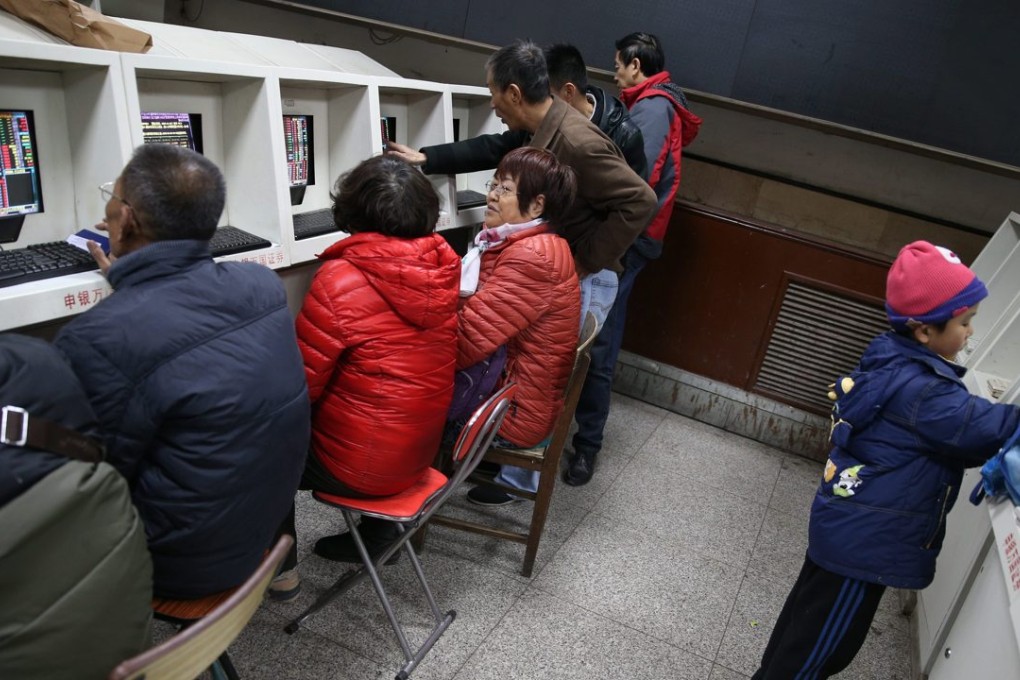 Stock investors watch stock prices in front of an electronic screen showing the stock prices at a brokerage house in Beijing on November 16. Photo: EPA