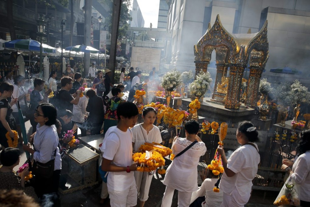 People pray at the renovated Erawan Shrine after Brahmin priests worshipped there. The renovations followed the deadly bombing of 17 August, which killed 20 and injured 123. Photo: EPA