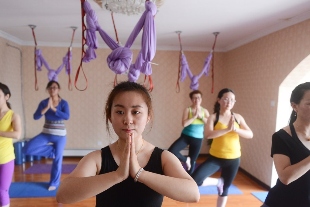 Cao Limeng (center) quit her job and went back to her home city of Xining to found her own yoga club in 2013. She now has two yoga clubs and more than 200 members. Photo: Xinhua