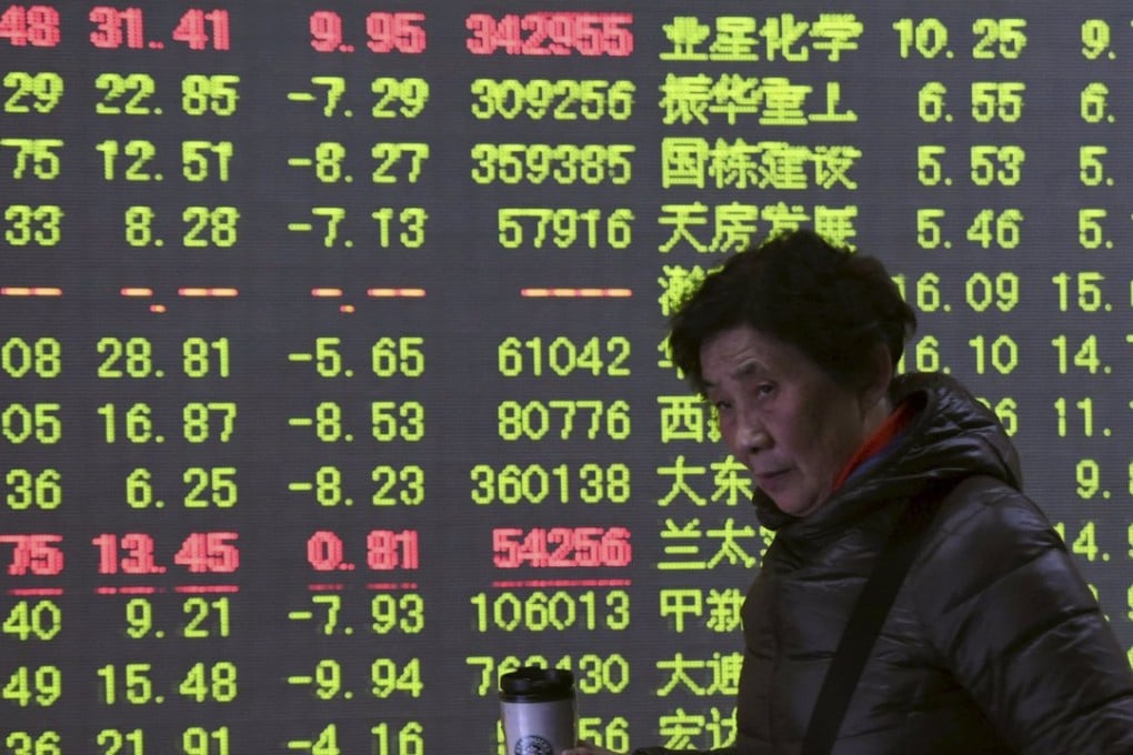 An investor walks past in front of an electronic board showing stock information at a brokerage house in Hangzhou, Zhejiang province on November 27. Photo: Reuters