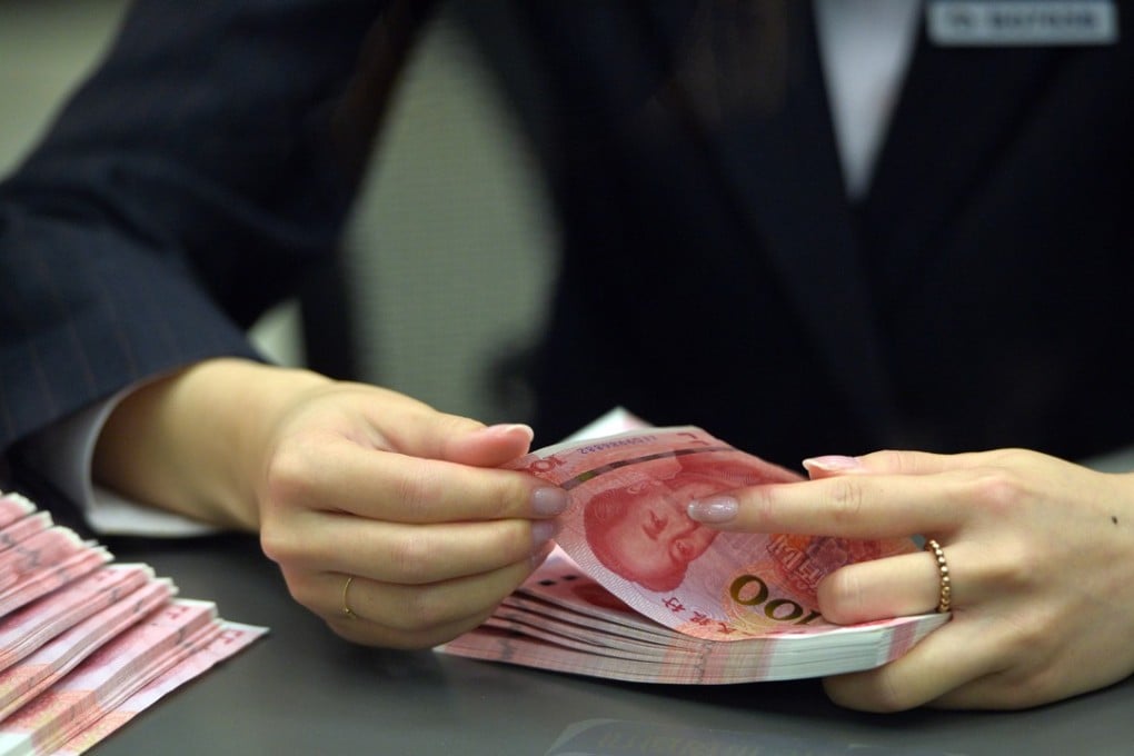 A bank staff member counts new 100-yuan banknotes at the Beijing Branch of the Bank of Communication in Beijing on November 12. Photo: Xinhua