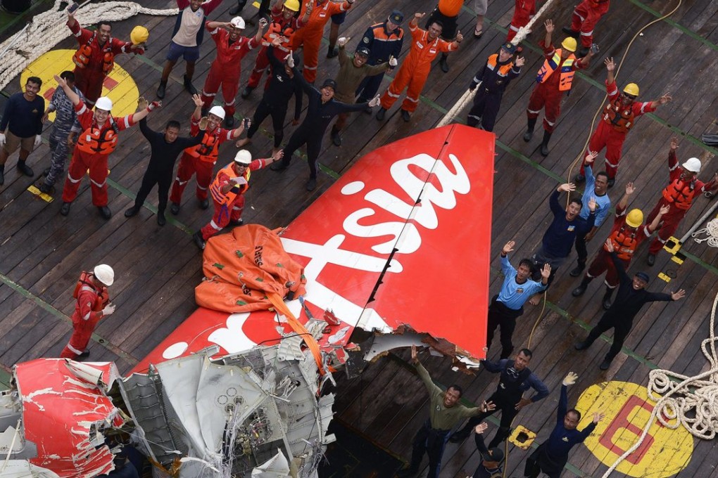 Rescuers and divers with the tail of AirAsia QZ8501 plane on the deck of the Indonesian Rescue ship Crest Onyx after lifted from the sea floor off Pangkalan Bun, Central Borneo, Indonesia in January 2015. Photo: EPA