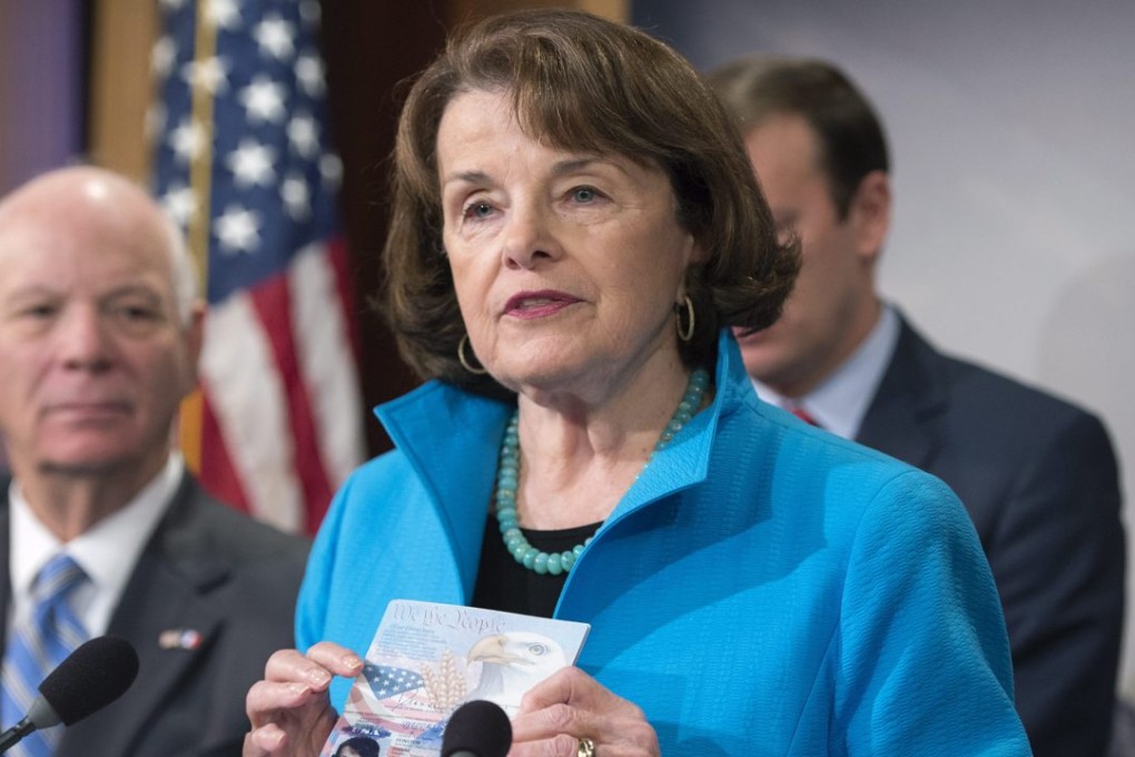 Democratic Senator Dianne Feinstein holds up her passport beside Democratic Senator from Maryland Ben Cardin (left) during a news conference on the visa waiver programme in Washington on November 19. Photo: EPA