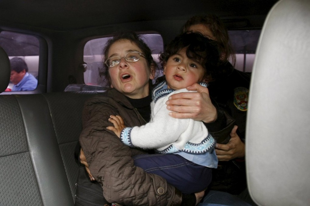 US citizen Lori Berenson carries her son in a police vehicle while being taken to court in Lima on August 18, 2010. Photo: Reuters