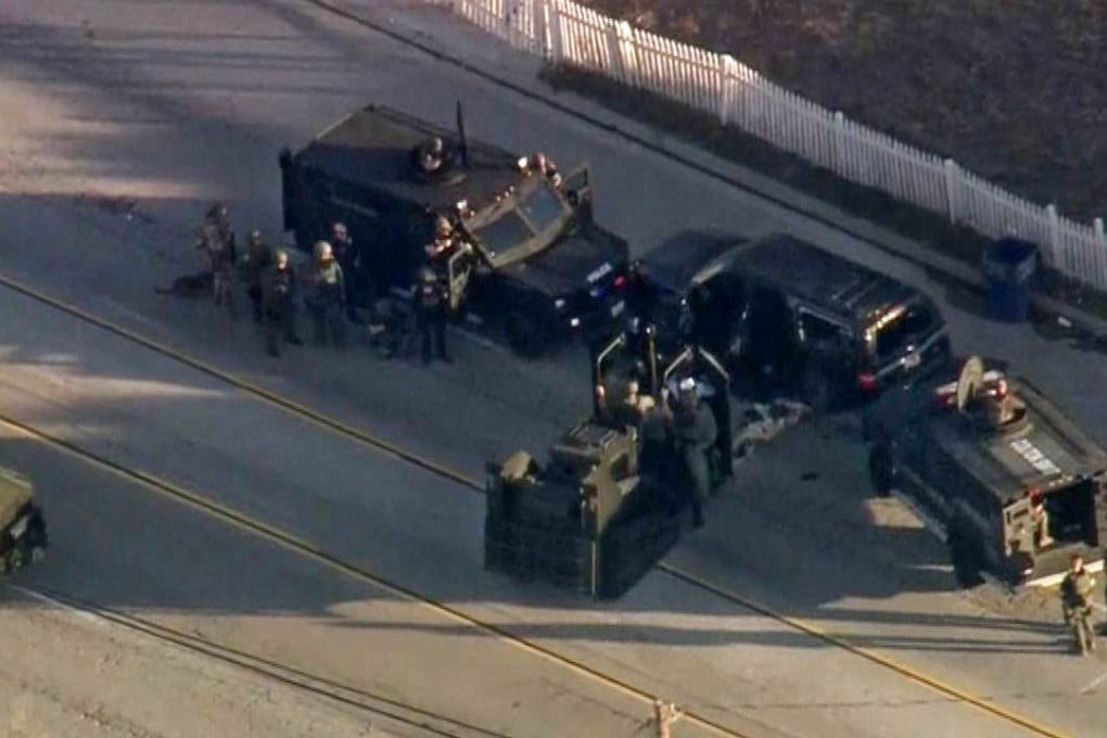 A still image from video courtesy of CBS News shows police in San Bernardino, California surrounding an SUV during an apparent shootout with suspects believed responsible for a mass shooting that left at least 14 people dead. Photo: AFP