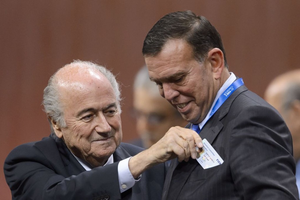 In this file photo, Fifa president Sepp Blatter gives an executive member card to South American Football Confederation (Conmebol) president Juan Angel Napout during the 65th congress on May 29. Photo: AFP