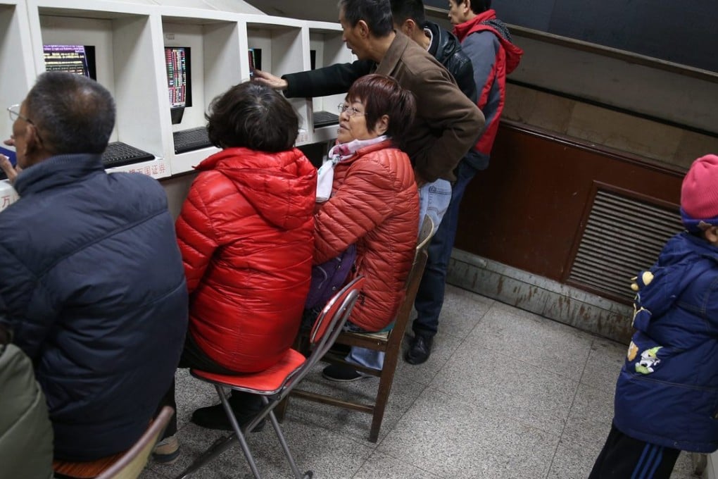 Investors watch stock prices at a brokerage in Beijing. Photo: EPA