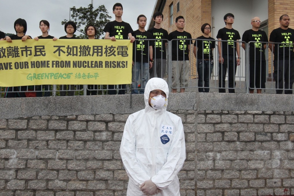 A rescue worker stands in front of anti-nuclear protesters near the Ma Liu Shui ferry pier during an evacuation drill at Daya Bay Nuclear Plant in 2012. Photo: Felix Wong