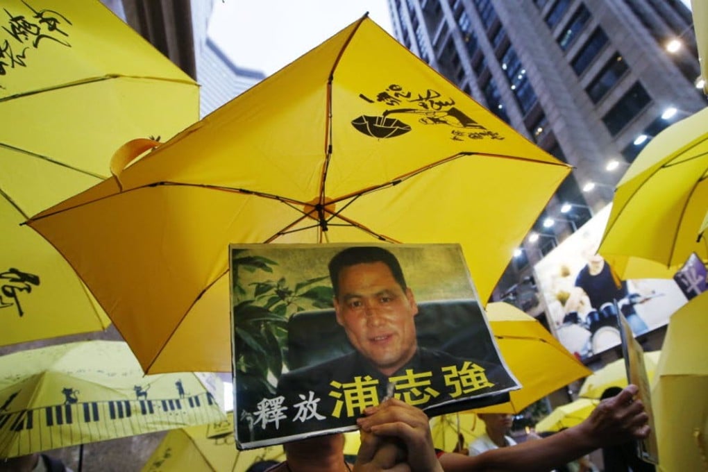Protesters in Hong Kong hold a picture of human rights lawyer Pu Zhiqiang. Photo: AP