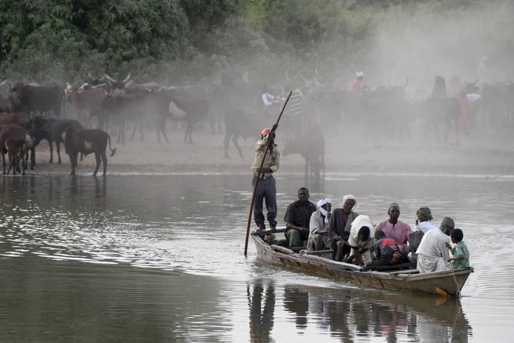 A picture taken in March shows people riding a boat to cross a section of Lake Chad whose waters border Niger, Nigeria and Cameroon in the village of Guite. A perfect storm of drought, poverty and armed conflict in Africa's Lake Chad basin is fuelling a migration crisis. Photo: AFP