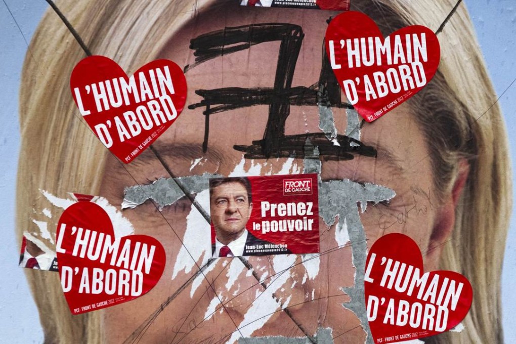 In a condensed display of the far left and far right politics in France, Marine Le Pen’s poster was defaced with a Nazi swastika on the eve of the first round of the presidential election. Stickers read: "Take power. Human first". Photo: AFP