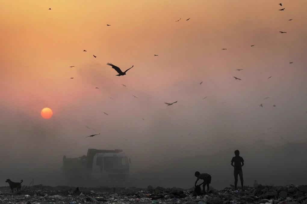 A thick blanket of smog obscures young scavengers at a garbage dump in New Delhi. Efforts are being made to cut traffic jams and fight extreme air pollution that has earned India’s capital the title of world's most polluted city. Photo: AP