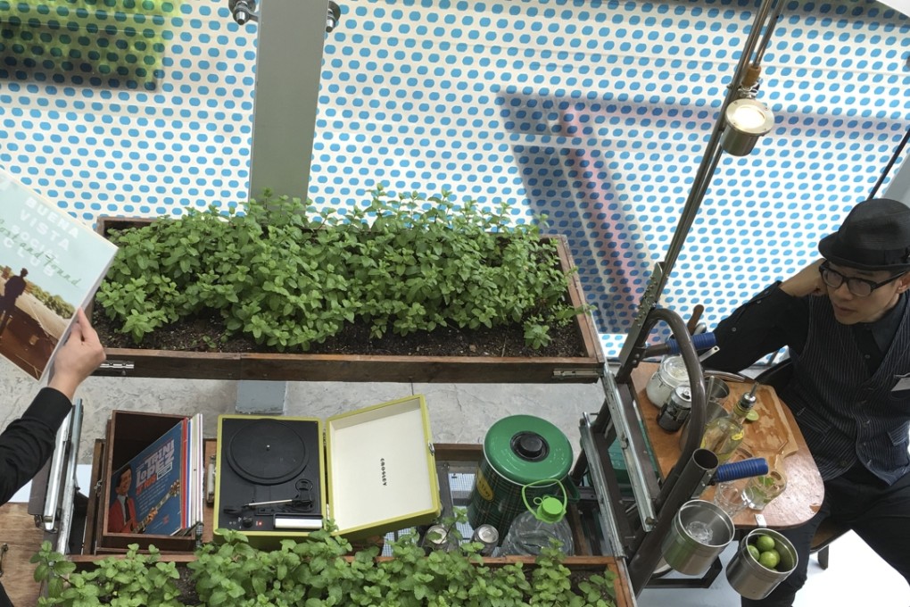 Kacey Wong (right) at his mobile minibar with built in mint farm for serving mojitos - on display at the Urbanism/Architecture Bi-City Biennale in Kowloon Park,