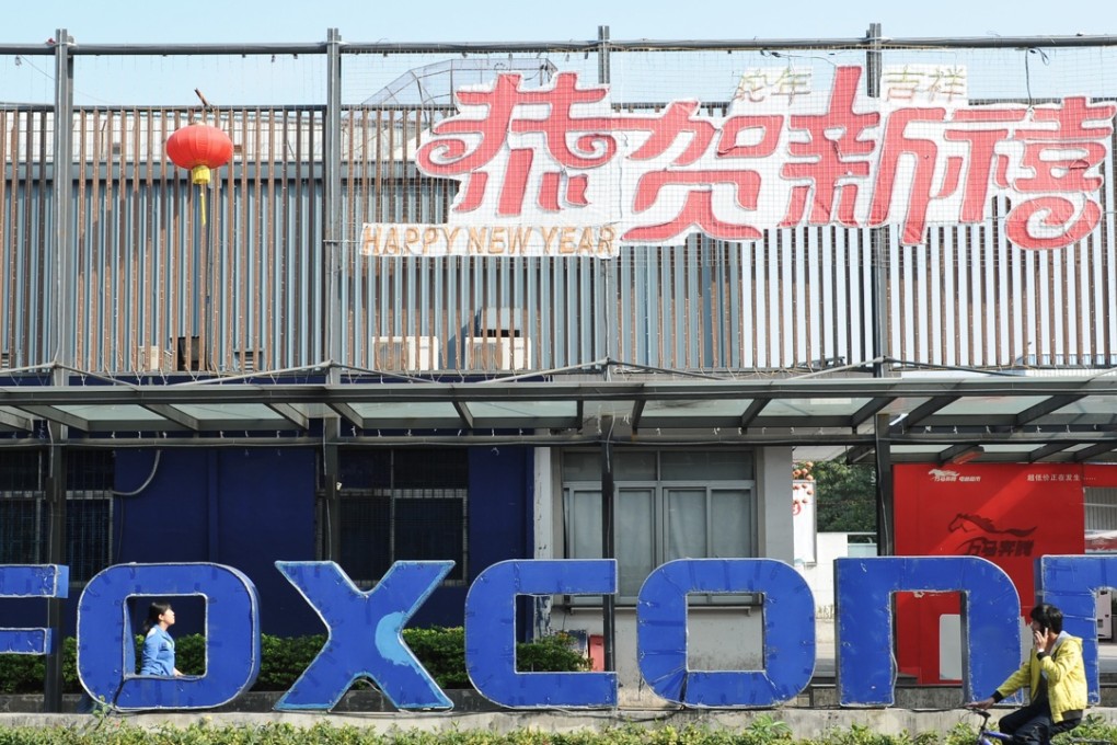 People walking past a Foxconn recruitment point in Shenzhen, in China's Guangdong province. The Taiwanese technology giant is a key company in manufacturing the iconic iPhones of Apple. Photo: AFP