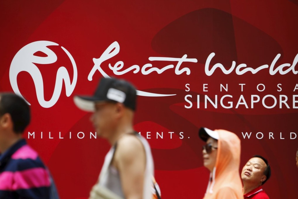People walk past a logo of Genting Singapore's Resorts World Sentosa in Singapore. Photo: Reuters