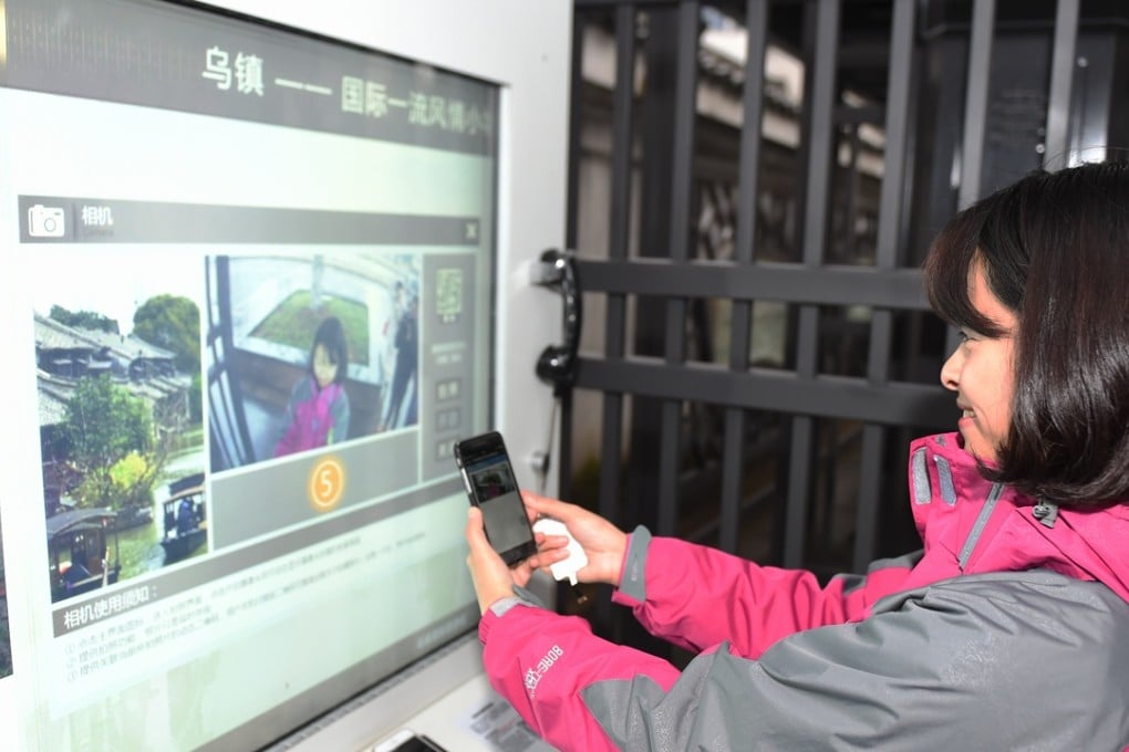 A young Chinese experiences selfie service in front of an information pavilion in Wuzhen Township in China's Zhejiang province, Photo: Xinhua