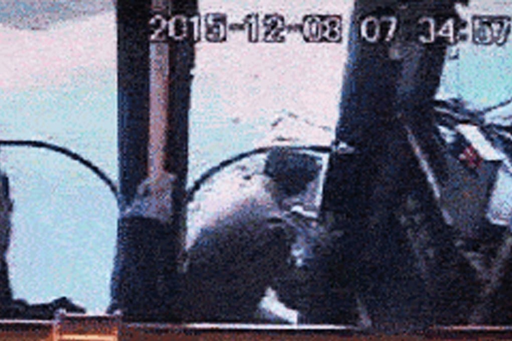 The passenger squeezes through the hole smashed in the bus door. Photo: SCMP Pictures