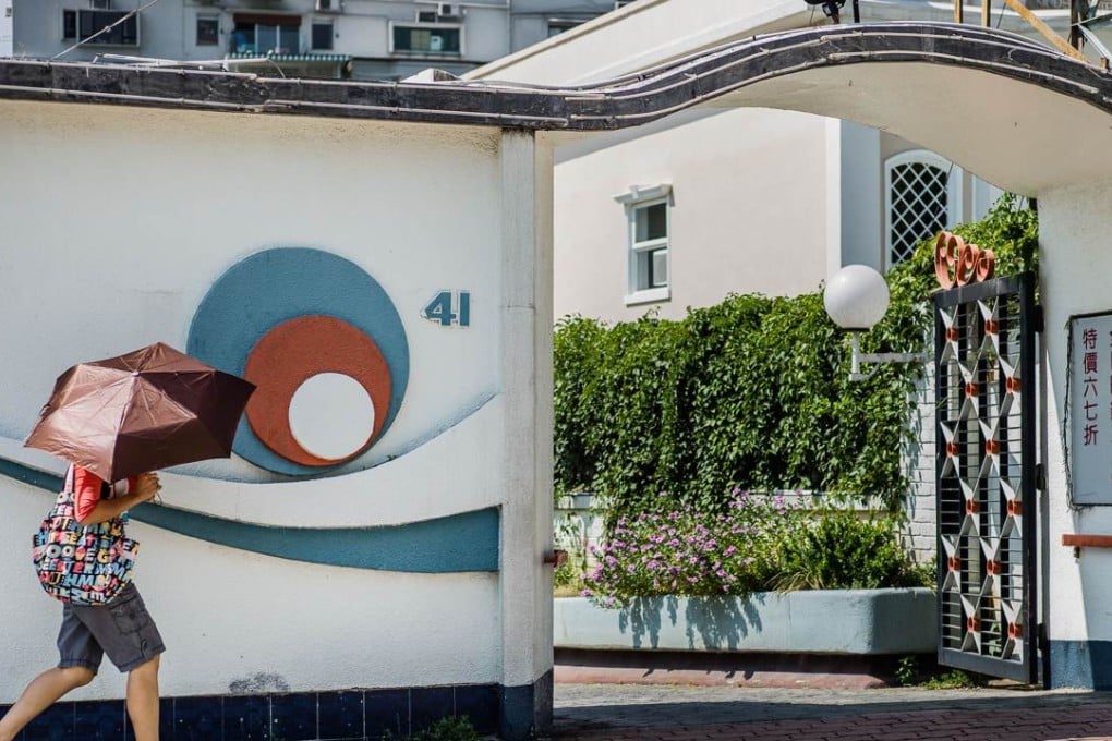 A woman walks past Bruce Lee's old home in Cumberland Road, Kowloon Tong. Photo: AFP
