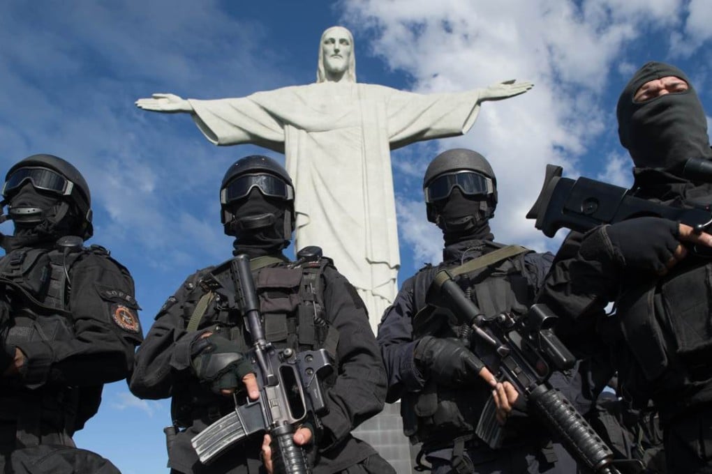 Members of the Elite Unit of the Special Police Operations Battalion (BOPE) posing between manoeuvres by the Christ the Reedemer statue in Rio de Janeiro, Brazil. Photo: AFP