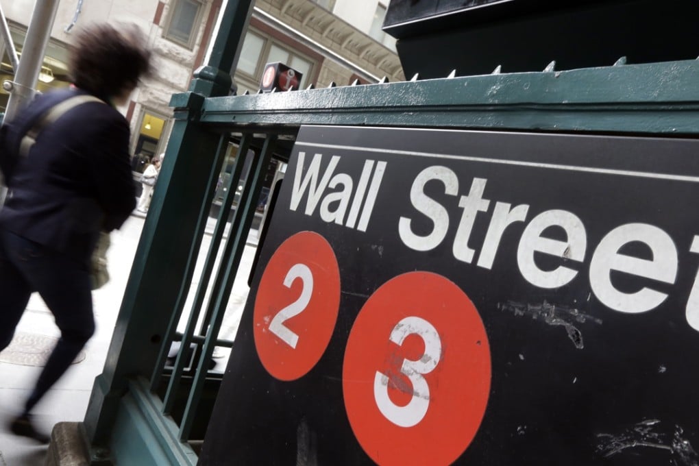 People pass a Wall Street subway stop, in New York's Financial District as options by global policymakers are narrowing with US interest rates poised to rise this week for the first time in nearly a decade. Photo: AP