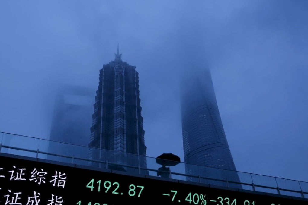 A man walks past an electronic board showing the benchmark Shanghai and Shenzhen stock indices on June 26. Photo: Reuters
