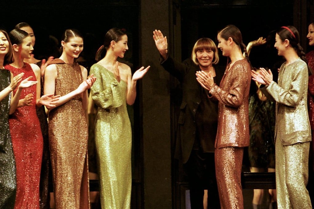 Mariuccia Mandelli waves from a Milan catwalk after presenting her autumn-winter 1996 collection. Photo: AP