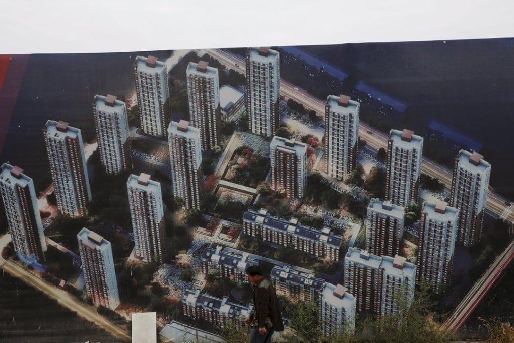 A man walks past a wall at a construction site for a new residential compound at the Binhai new district in Tianjin on October 18. Photo: Reuters