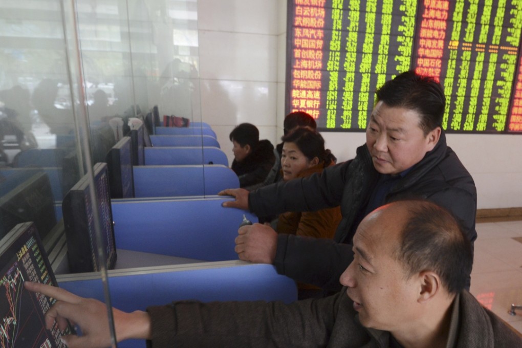 Chinese investors check stock prices on computer terminals at a brokerage house in Fuyang in central China's Anhui province as punters eye the reaction of markets in Shanghai and Shenzhen after the US Fed raised interest rates for the first time in almost a decade. Photo: AP