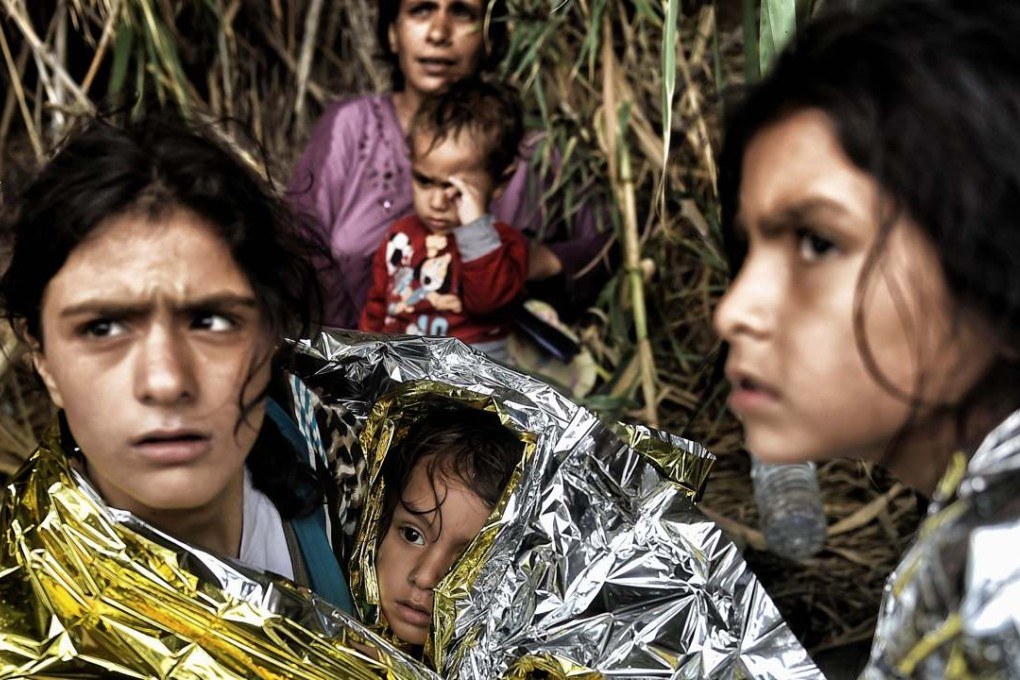 Syrian refugees are covered with insulating blankets upon arrival on the Greek island of Lesbos, after crossing the Aegean sea from Turkey, in September. Photo: AFP