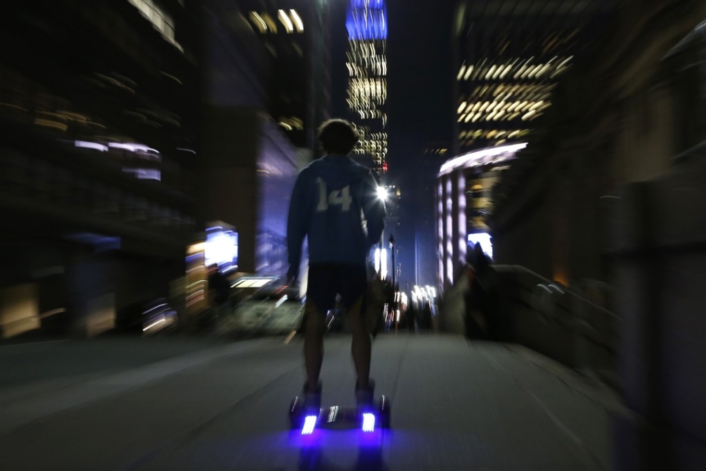 A young man rides a hoverboard along a Manhattan street towards the Empire State Building, in New York, despite a ban on their use on public roads in the city. Photo: AP
