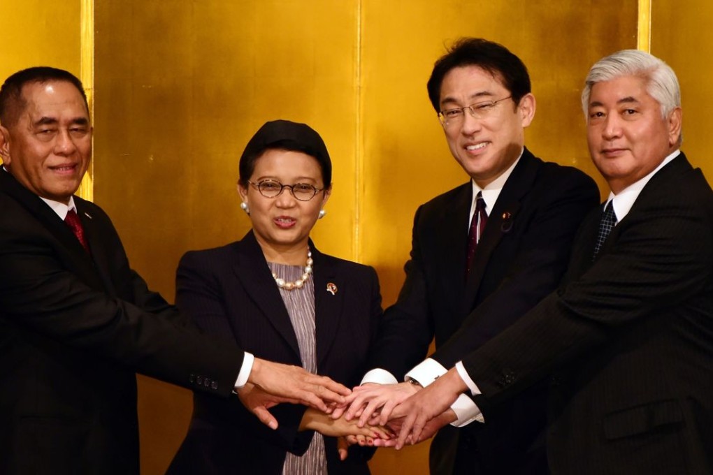 Indonesian Defence Minister Ryamizard Ryacudu, Indonesian Foreign Minister Retno Marsudi, Japanese Foreign Minister Fimio Kishida and Japanese Defence Minister Gen Nakatani shake their hands before first Indonesia-Japan foreign and defence ministers meeting in Tokyo. Photo: AFP